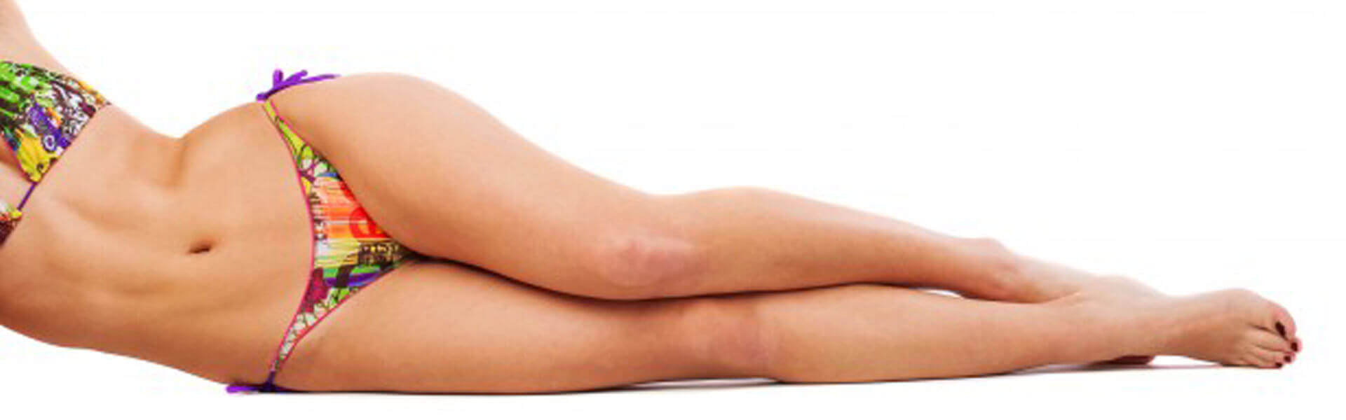 Picture of a female laying on her side proud of her well shaped legs after having her liposuction done at Nova Plastic Surgery Center in Guadalajara, Mexico.